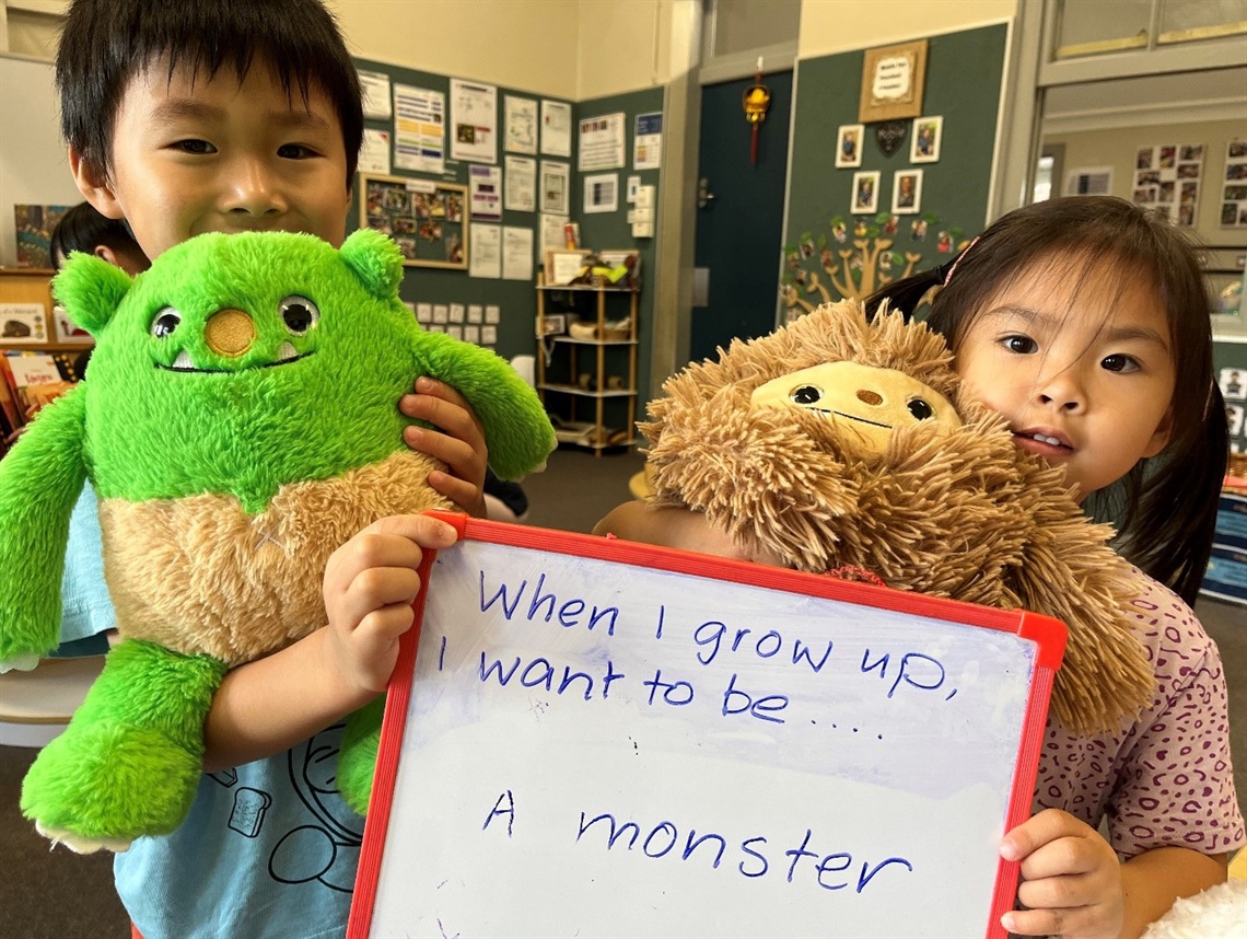 Children holding up sign which says - when I grow up, I want to be a monster