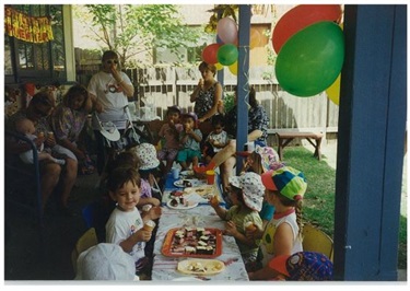 Young children sitting around a table and eating assorted snacks at morning tea