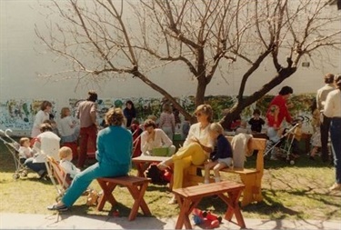 Adults and young children sitting on benches together