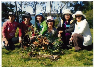 Group of women smiling and posing with plants at  Educators' conference