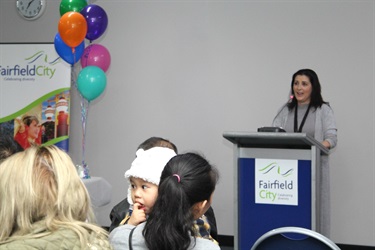 Family Day Care educator standing behind a podium and speaking into a microphone